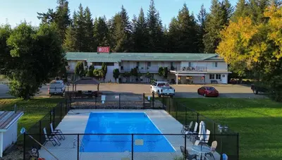 a pool in front of a building with a parking lot at Clearwater Country Inn in Clearwater
