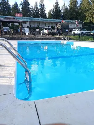 a swimming pool with blue water in front of a motel at Clearwater Country Inn in Clearwater