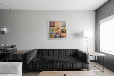 a living room with a black leather couch at Premier Residence - Fort McMurray in Fort McMurray