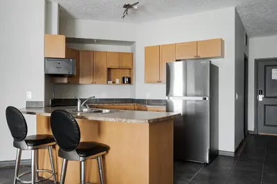 a kitchen with a sink and a refrigerator at Premier Residence - Fort McMurray in Fort McMurray