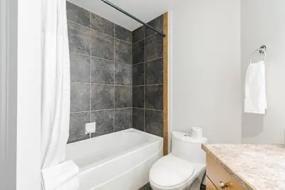 a bathroom with a white tub and a toilet at Premier Residence - Fort McMurray in Fort McMurray