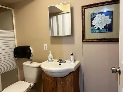 a bathroom with a sink and a toilet and a mirror at Beautiful room close Airport! in Calgary