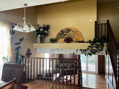 a living room with a staircase and a chandelier at Beautiful room close Airport! in Calgary