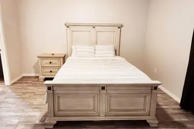 a large bed in a bedroom with a wooden frame at Comfort First - sleeps 6 in Whitehorse