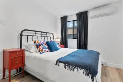 a bedroom with a bed and a nightstand and a window at Mid-Century Modern Dream Retreat in West Kelowna