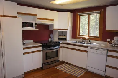 a kitchen with white cabinets and a stove top oven at Fairmont Mountain Bungalows in Fairmont Hot Springs