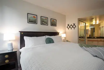 a bedroom with a large white bed and a mirror at 1BR in Marquise, Close to Ski Hill, Pool, Sauna, Hot Tub, Fitness Suite, Fireplace in Whistler