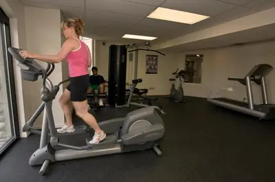 a woman on a treadmill in a gym at 1BR in Marquise, Close to Ski Hill, Pool, Sauna, Hot Tub, Fitness Suite, Fireplace in Whistler