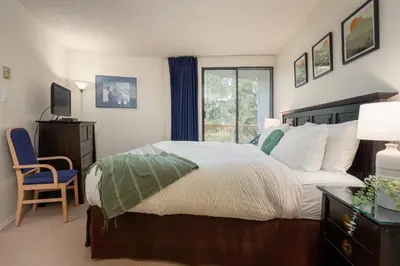 a bedroom with a large bed and a window at 1BR in Marquise, Close to Ski Hill, Pool, Sauna, Hot Tub, Fitness Suite, Fireplace in Whistler
