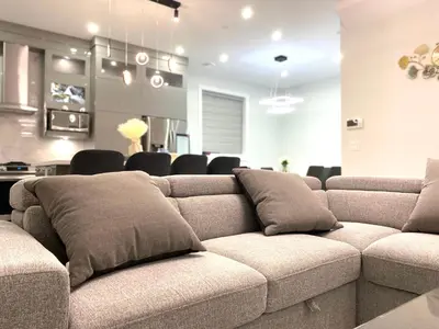a living room with a couch with pillows on it at Modern and New house near PNE with Big Garden and Free Parking in Vancouver
