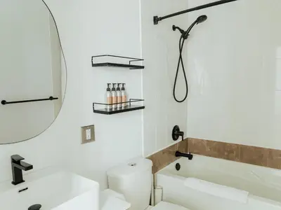 a bathroom with a toilet and a sink and a mirror at Ucluelet Wildwood Inn in Ucluelet