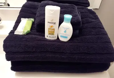 a black towel with two bottles of moisturizing products on it at Comfy KING Bed, Large private Basement Suite, Smart TV in Penticton- city of PEACHES AND BEACHES in Penticton
