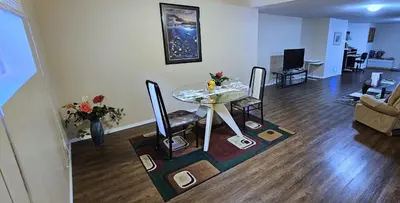 a living room with a glass table and chairs at Comfy KING Bed, Large private Basement Suite, Smart TV in Penticton- city of PEACHES AND BEACHES in Penticton