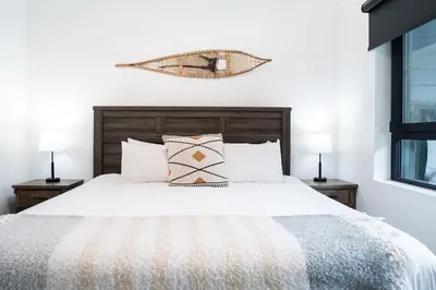 a bedroom with a white bed with two lamps at The Grizzly Basin by Revelstoke Vacations in Revelstoke