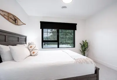 a bedroom with a large white bed with a window at The Grizzly Basin by Revelstoke Vacations in Revelstoke