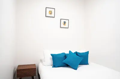 a white bedroom with blue pillows on a bed at Rummy's Adventure Bay by Revelstoke Vacations in Revelstoke
