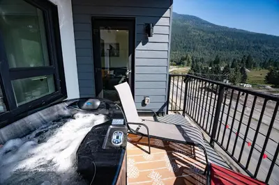 a balcony of a house with a chair on it at Rummy's Adventure Bay by Revelstoke Vacations in Revelstoke