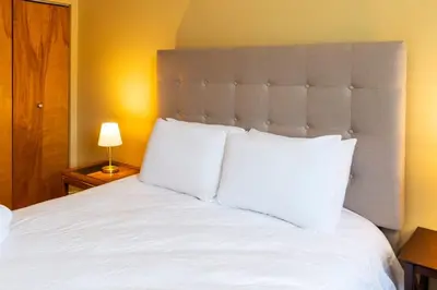 a large white bed with white pillows in a bedroom at NN - The Loft - Downtown 1-bed 2-bath in Whitehorse