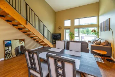a dining room with a table and chairs and a staircase at NN - The Loft - Downtown 1-bed 2-bath in Whitehorse