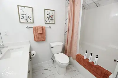 a bathroom with a toilet and a tub and a sink at Beautiful 3 King Beds,Garage,Airport,Disney+ in Edmonton
