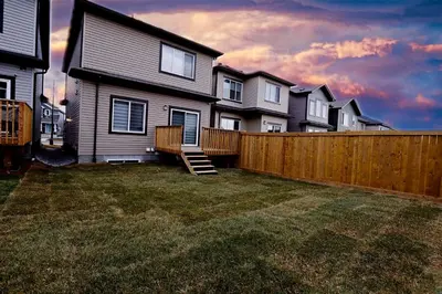 a house with a wooden fence in a yard at Beautiful 3 King Beds,Garage,Airport,Disney+ in Edmonton