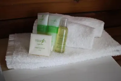 a pile of towels and a bottle of essential oils at Jewel Bay Resort in Sorrento