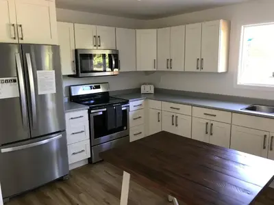 a kitchen with white cabinets and stainless steel appliances at Jewel Bay Resort in Sorrento