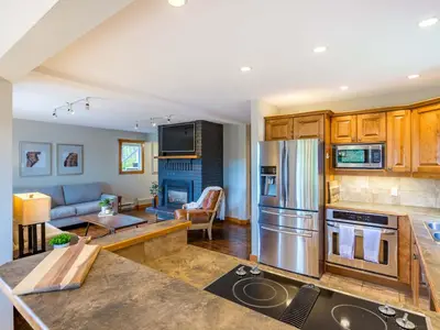 a kitchen and living room with a stainless steel refrigerator at The Alpine I No Service Fee's I Ski-in Ski-Out I in Silver Star