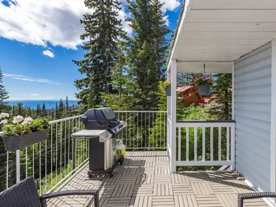 a patio with a trash can and a fence at The Alpine I No Service Fee's I Ski-in Ski-Out I in Silver Star