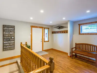 a living room with a bench and a door at The Alpine I No Service Fee's I Ski-in Ski-Out I in Silver Star