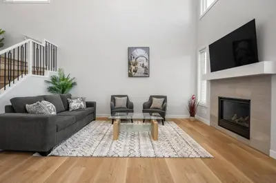 a living room with a couch and a fireplace at Bright & Spacious 3 Beds Luxury Home in SE Calgary in Calgary