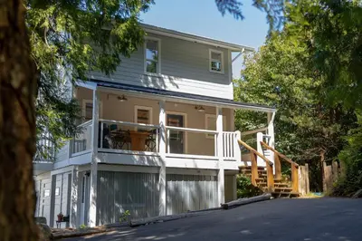 a house with a wrap around porch at Surfs Inn Guesthouse & Cottages in Ucluelet