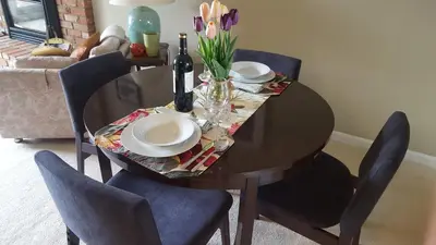 a dining room table with two plates and wine bottles on it at Window Hill in St. Albert
