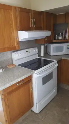 a kitchen with a stove and a microwave at Window Hill in St. Albert