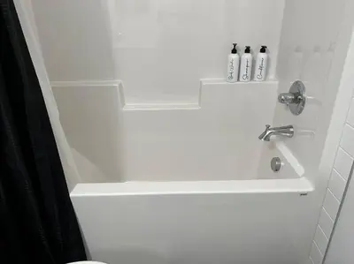 a white bathroom with a shower with a sink at Modern Luxury Private Suite in Airdrie