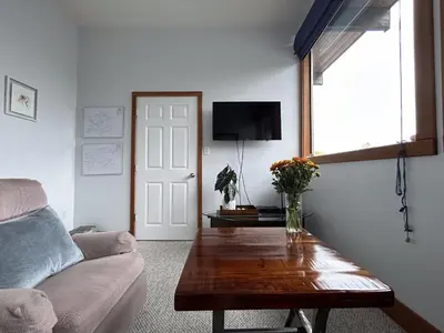 a living room with a couch and a table at Charming Hidden Gem- Ocean View and Marina in Campbell River