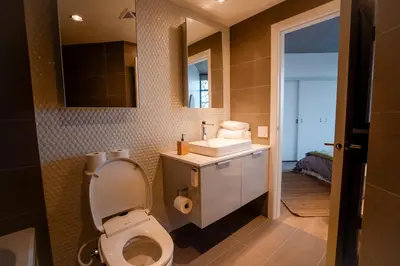a bathroom with a toilet and a sink at High rise Apartment in Vancouver
