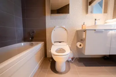 a bathroom with a toilet and a tub and a sink at High rise Apartment in Vancouver