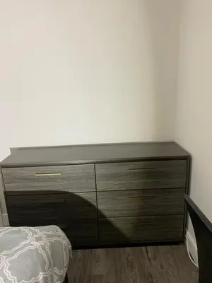 a wooden dresser in a bedroom with a bed at Entire 2BR Guest House in Quiet Area in Nanaimo