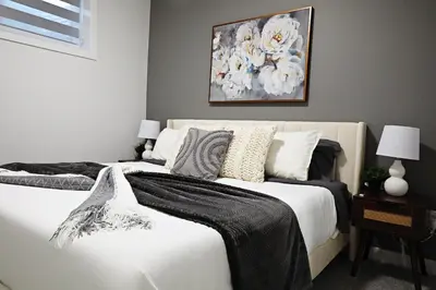 a bedroom with a bed and a painting on the wall at Beautiful Suite King Bed,Long Stays,Disney,Airport in Edmonton