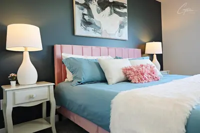 a bedroom with a blue bed with a pink headboard at Beautiful Home With 4 King Beds,Airport,Disney+ in Edmonton