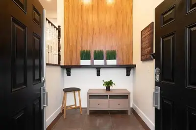 a hallway with a table and a stool next to a door at Westside Pool Home-8 min to Downtown, Yard Parking in Vancouver