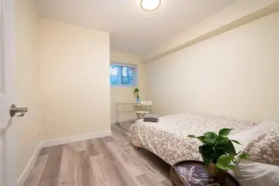 a bedroom with a bed and a plant in it at Westside Pool Home-8 min to Downtown, Yard Parking in Vancouver