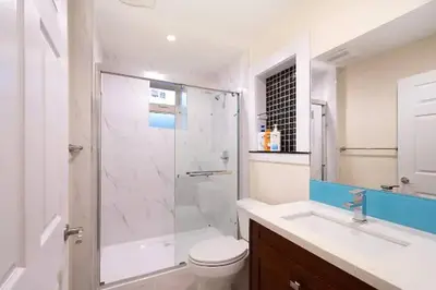 a bathroom with a shower and a toilet and a sink at Westside Pool Home-8 min to Downtown, Yard Parking in Vancouver