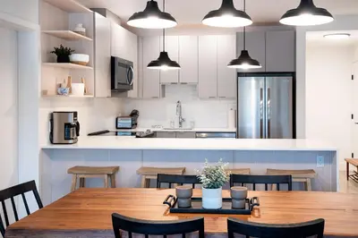 a kitchen and dining room with a wooden table and chairs at Farwell's Spike by Revelstoke Vacations in Revelstoke
