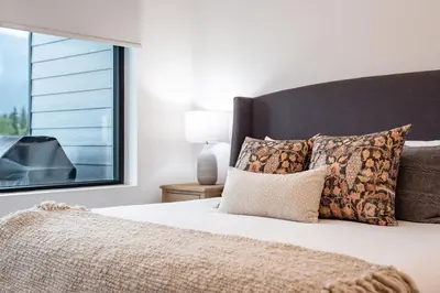 a bedroom with a bed with a large window at Farwell's Spike by Revelstoke Vacations in Revelstoke