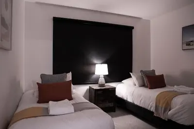 two beds in a room with a lamp on a table at RevelStoked Getaway by Revelstoke Vacations in Revelstoke
