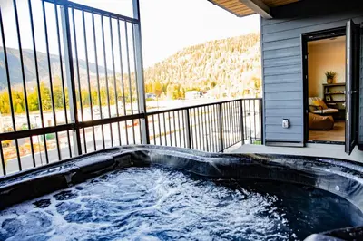 a hot tub on the balcony of a house at Revy Mountain Retreat in Revelstoke