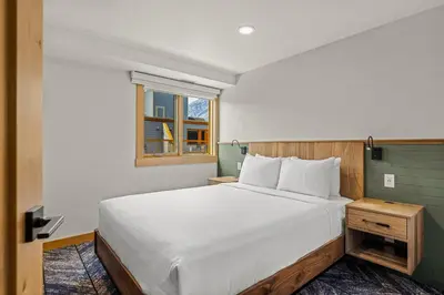 a bedroom with a large white bed and a window at Hotel Canoe and Suites in Banff