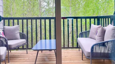 a porch with two chairs and a table on a balcony at Immersed in the scenery of Canmore in Canmore